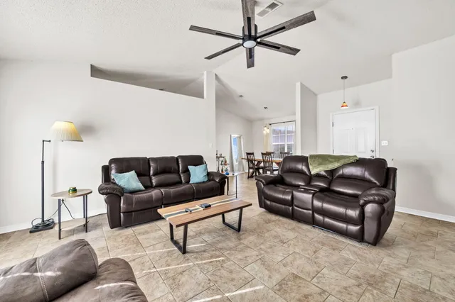 a living room with furniture and a ceiling fan