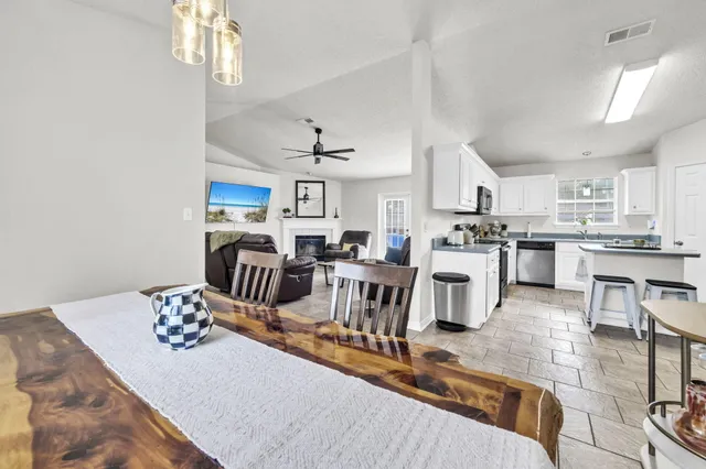 a living room with furniture kitchen view and a chandelier