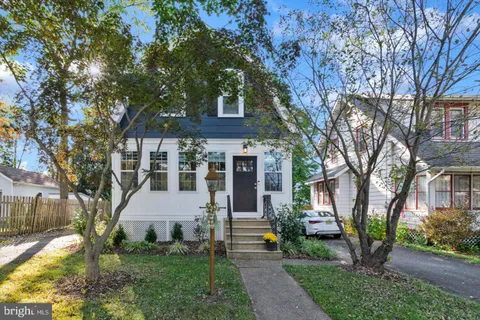 a view of house with a yard and potted plants