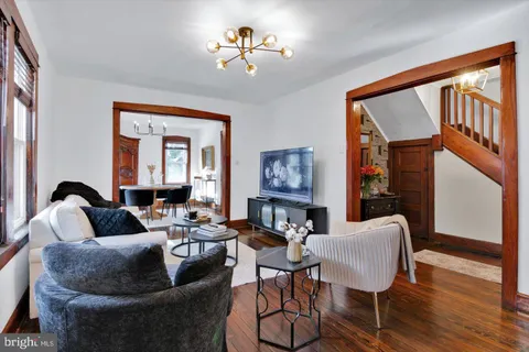 a dining room with furniture a chandelier and wooden floor