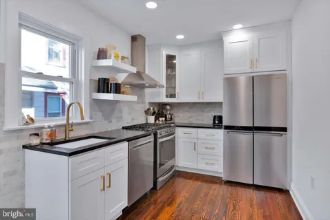 a view of a kitchen and an entryway with wooden floor