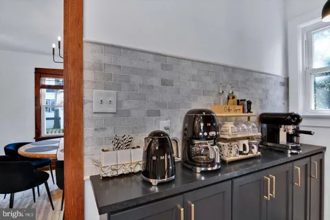 a bathroom with a granite countertop sink a toilet and a window
