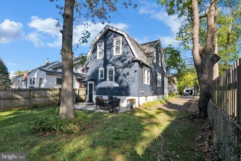 a view of a backyard with table and chairs under an umbrella