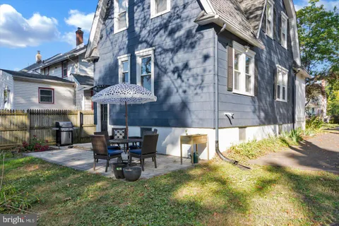 a view of a house with a big yard and large trees