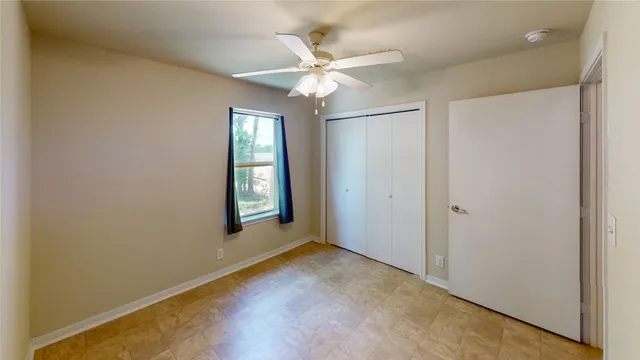 an empty room with fan and windows