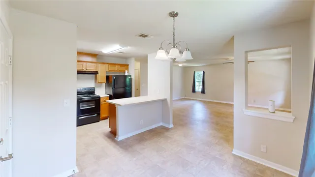 a view of a living room and kitchen with kitchen island stainless steel appliances