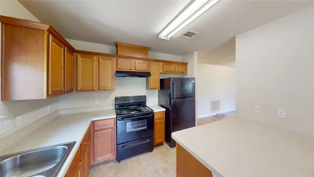 a kitchen with stainless steel appliances a refrigerator and a stove top oven