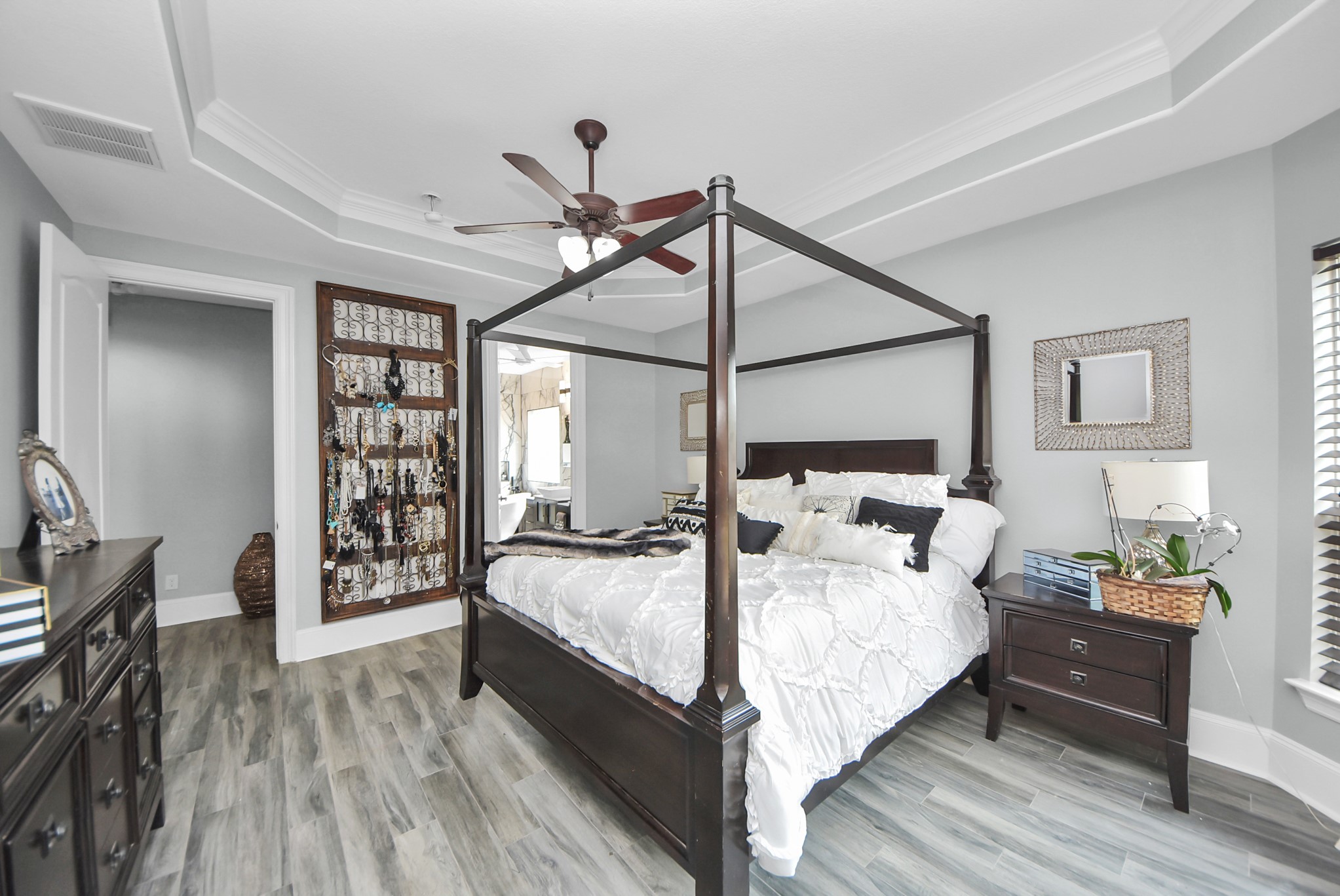 28115 Kudzu Drive Spring, TX 77386 - Photo 21 of 39 a bedroom with a bed a bookshelf and a wooden floor