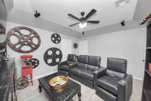 a living room with furniture a clock and a ceiling fan