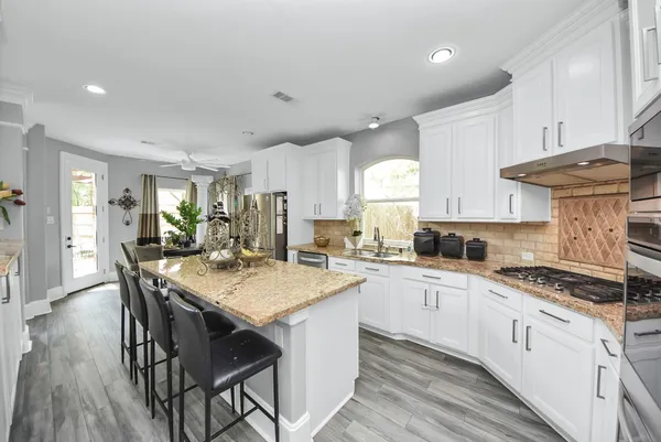a kitchen with granite countertop a sink stove and cabinets