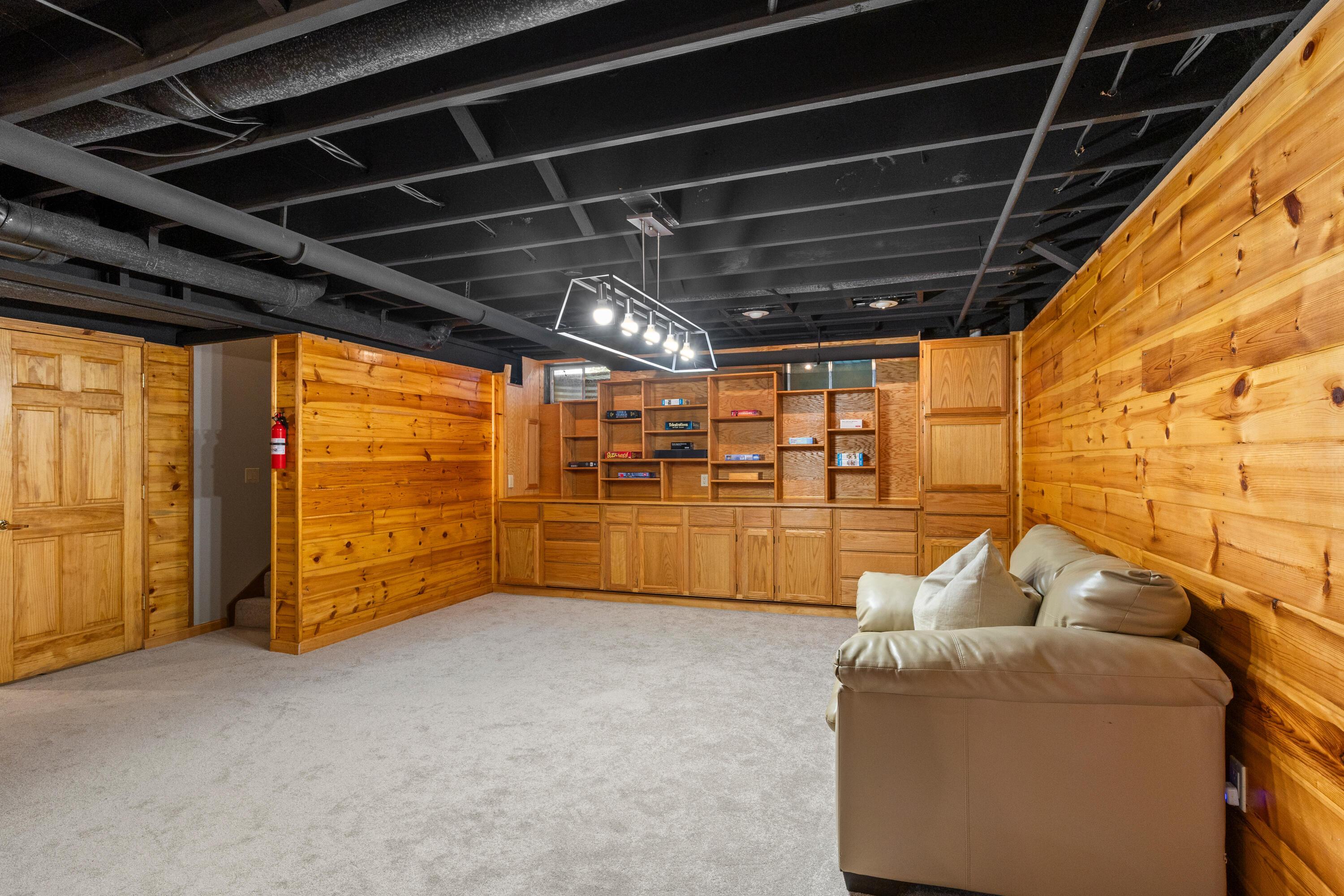 1515 Dale Ford Road Delaware, OH 43015 - Photo 50 of 74 • New light sand carpet ~ 2025 • Wood planked walls • Built-in shelves • Billiards light remains