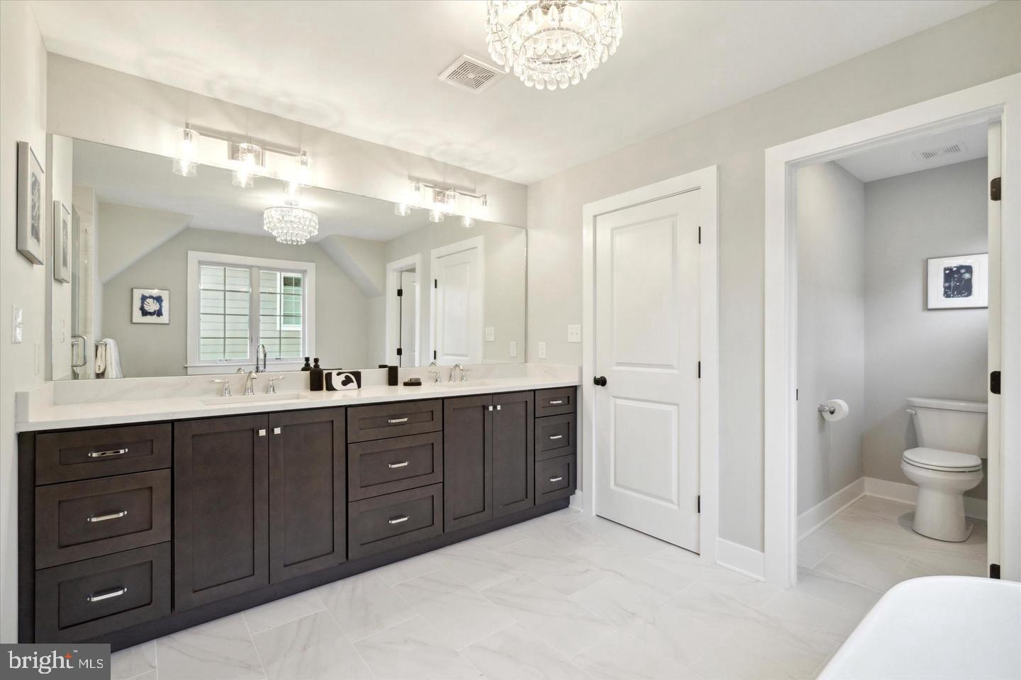 111 St Pauls Road Ardmore, PA 19003 - Photo 13 of 14 a spacious bathroom with a double vanity sink a large mirror a toilet and a shower