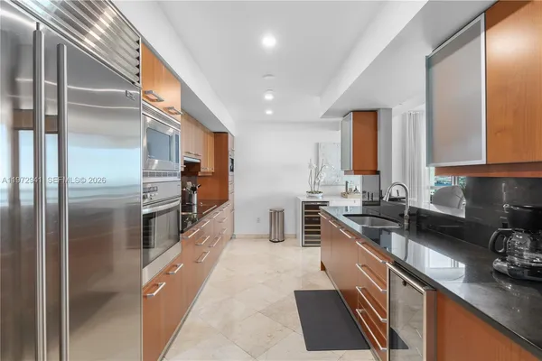 a kitchen with stainless steel appliances granite countertop a sink a stove and a refrigerator