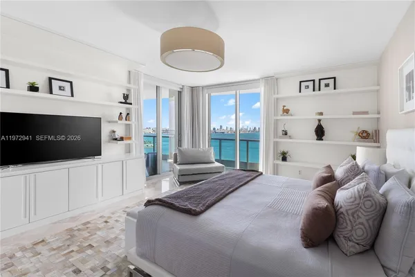 a large bedroom with a bed and a flat screen tv