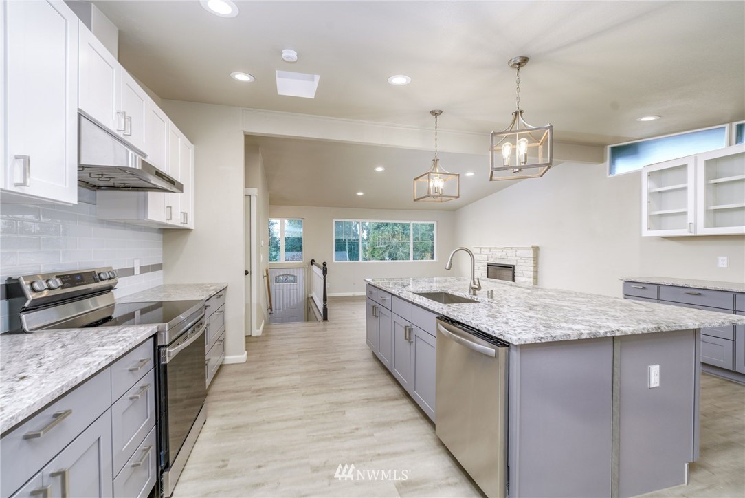 2926 Northeast 5th Place Renton, WA 98056 - Photo 3 of 40 a large kitchen with stainless steel appliances granite countertop plenty wooden cabinets counter space a sink and a stove