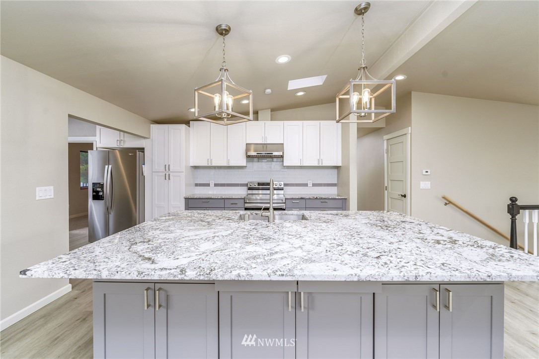 2926 Northeast 5th Place Renton, WA 98056 - Photo 8 of 40 a kitchen with stainless steel appliances kitchen island granite countertop a refrigerator a stove top oven and a sink with dishwasher