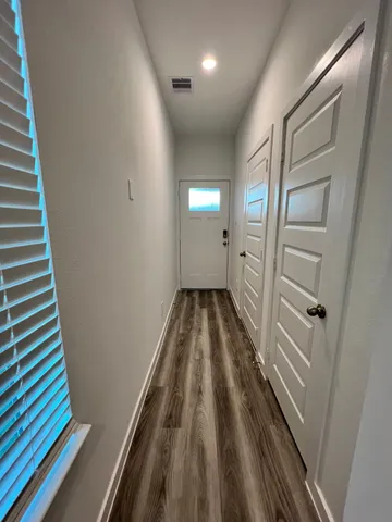 a view of a hallway and wooden floor