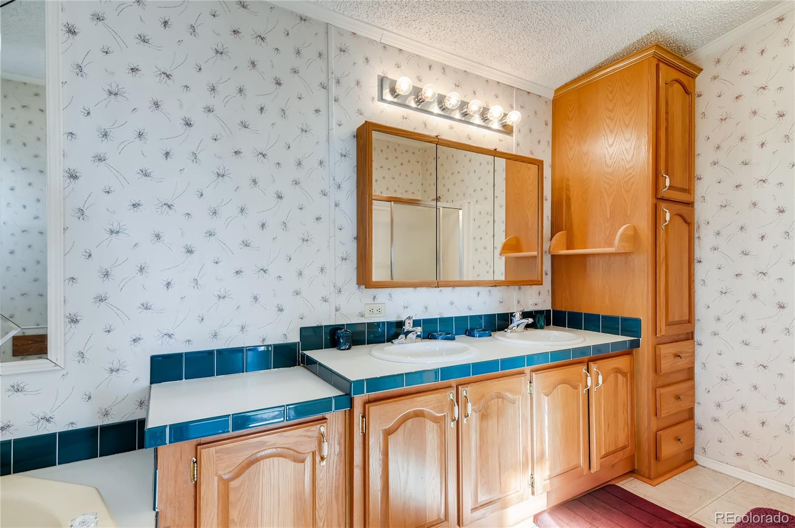 13801 Cavanaugh Road Hudson, CO 80642 - Photo 15 of 39 a bathroom with a sink a mirror and a shower