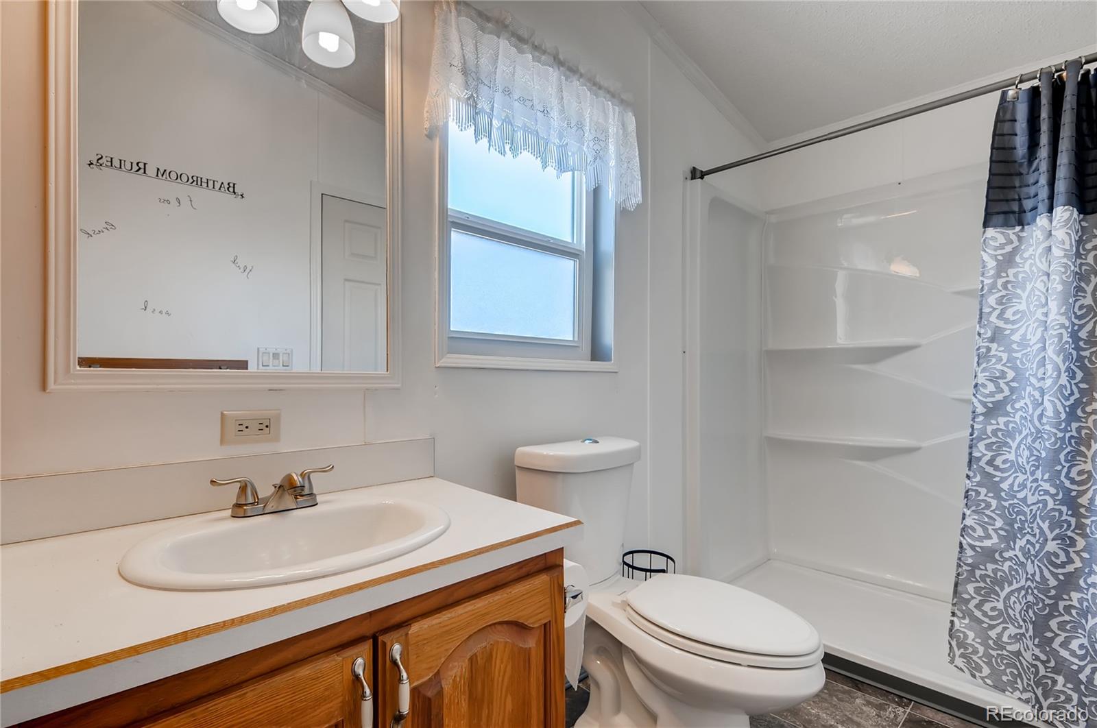13801 Cavanaugh Road Hudson, CO 80642 - Photo 25 of 39 a bathroom with a sink toilet vanity and shower