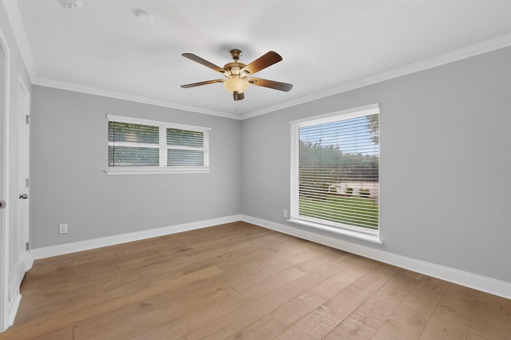 7631 Meadow Road Dallas, TX 75230 - Photo 26 of 40 A bright bedroom with a ceiling fan and wide windows