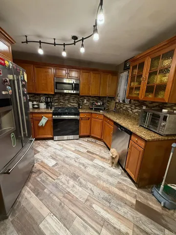 a kitchen with stove top oven and refrigerator