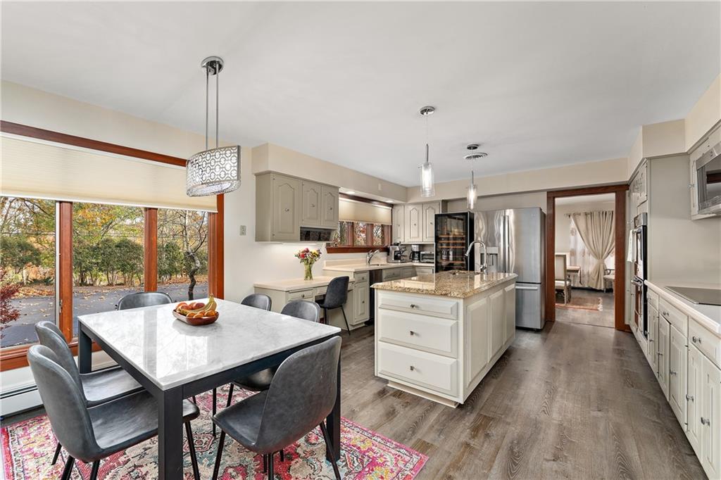 178 Backbone Road Sewickley, PA 15143 - Photo 8 of 25 a view of a dining room and livingroom with furniture wooden floor a rug a flat screen tv a rug and a chandelier