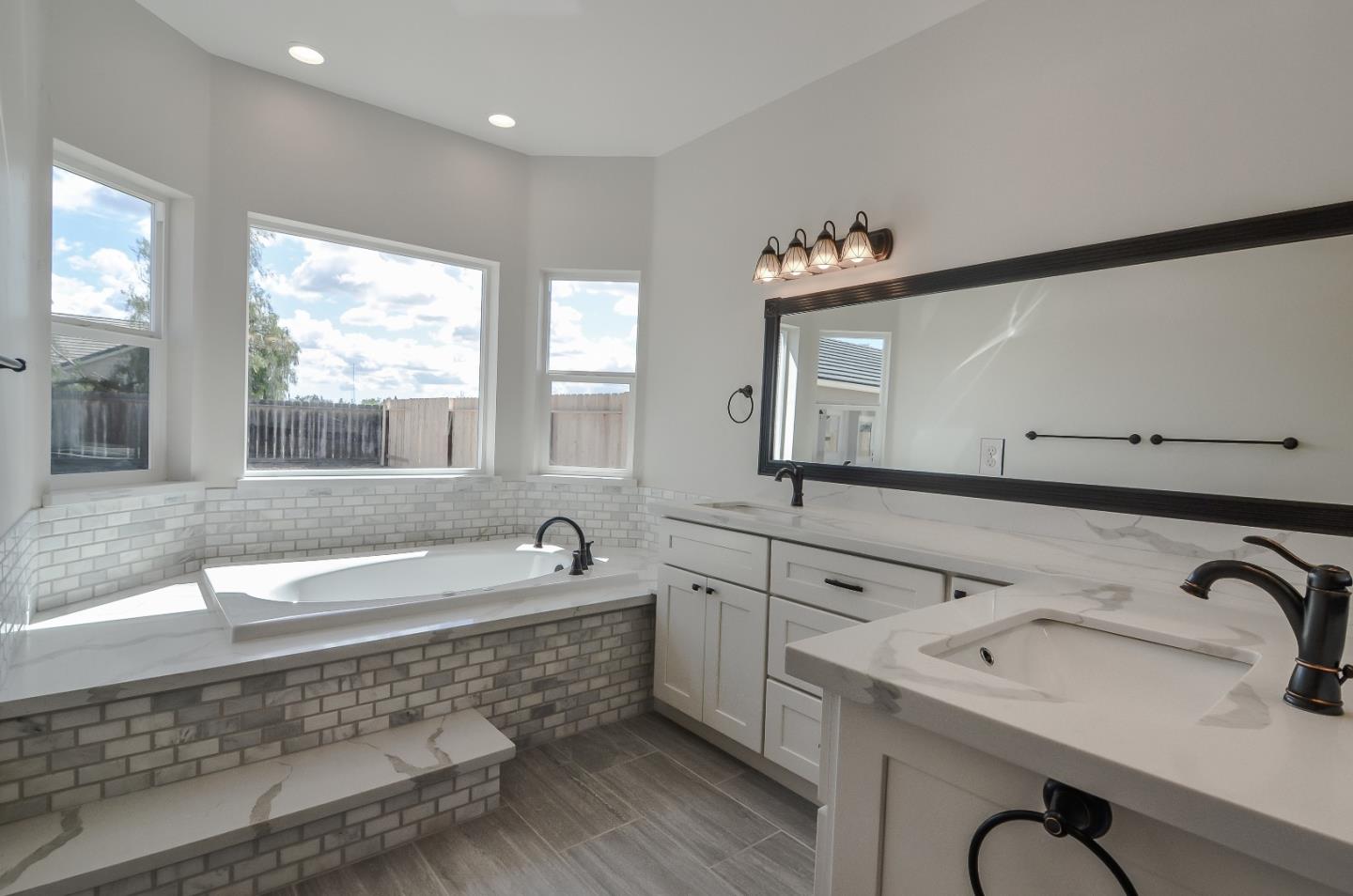 684 South Mohler Road Ripon, CA 95366 - Photo 28 of 41 a bathroom with a tub sink and mirror