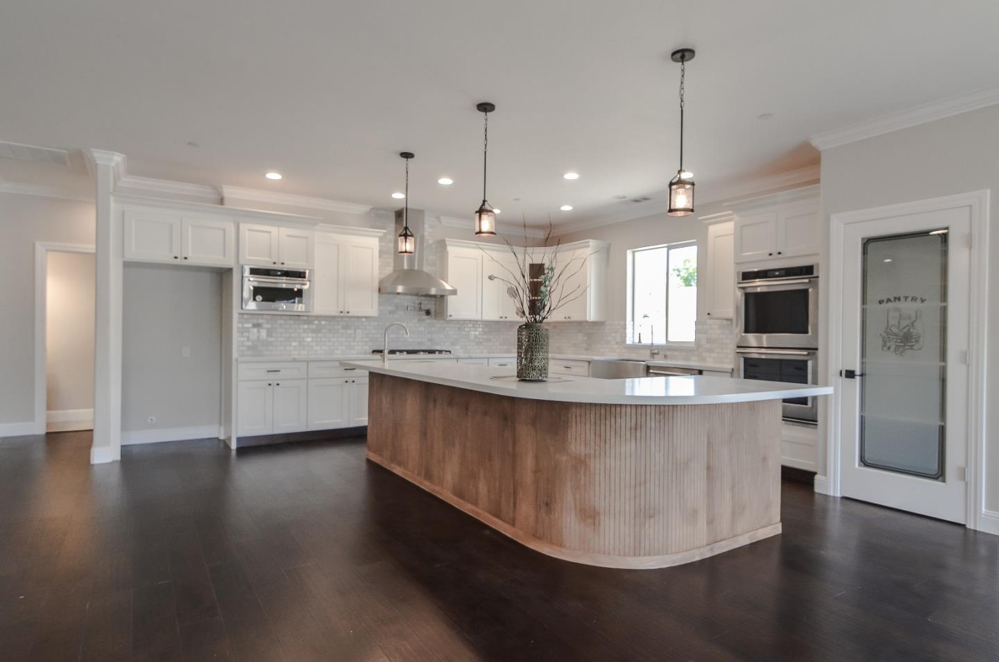684 South Mohler Road Ripon, CA 95366 - Photo 9 of 41 a large kitchen with stainless steel appliances kitchen island granite countertop a large center island a stove a refrigerator a sink a counter space and wooden floor