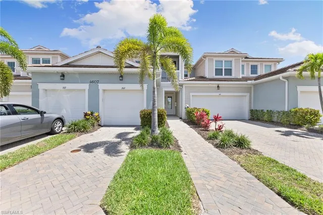 a front view of a house with a yard and potted plants