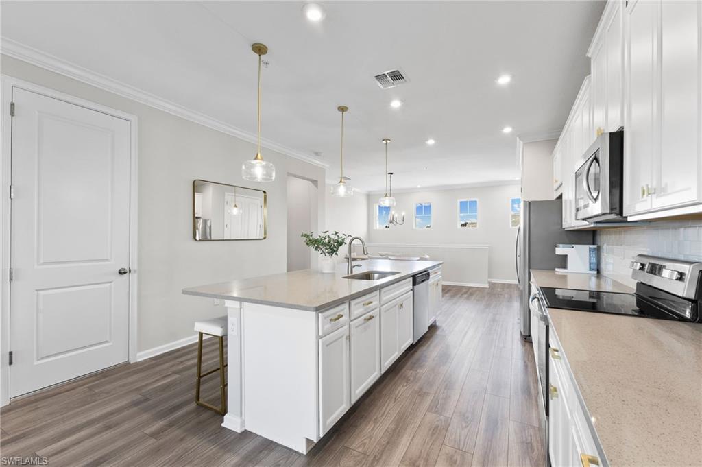 4607 Arboretum Circle, Unit 202 Naples, FL 34112 - Photo 22 of 39 a kitchen with a sink stove and wooden floor