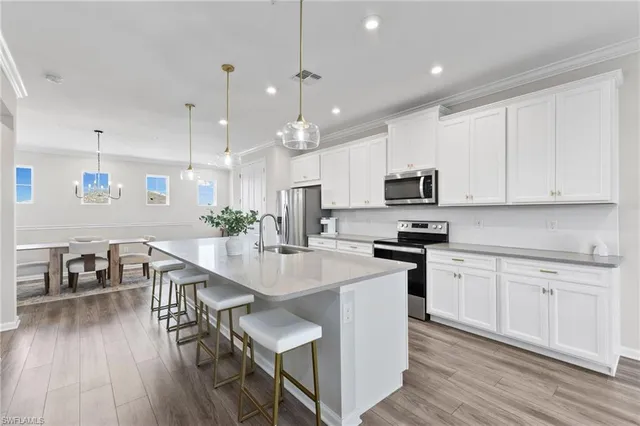 an open kitchen with kitchen island white cabinets and stainless steel appliances