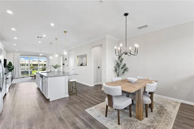 a view of a dining room with furniture wooden floor and chandelier
