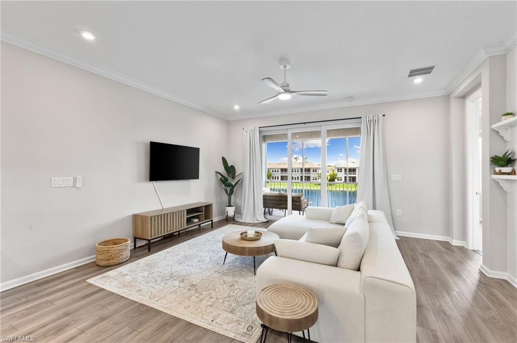 4607 Arboretum Circle, Unit 202 Naples, FL 34112 - Photo 6 of 39 a living room with furniture and a flat screen tv