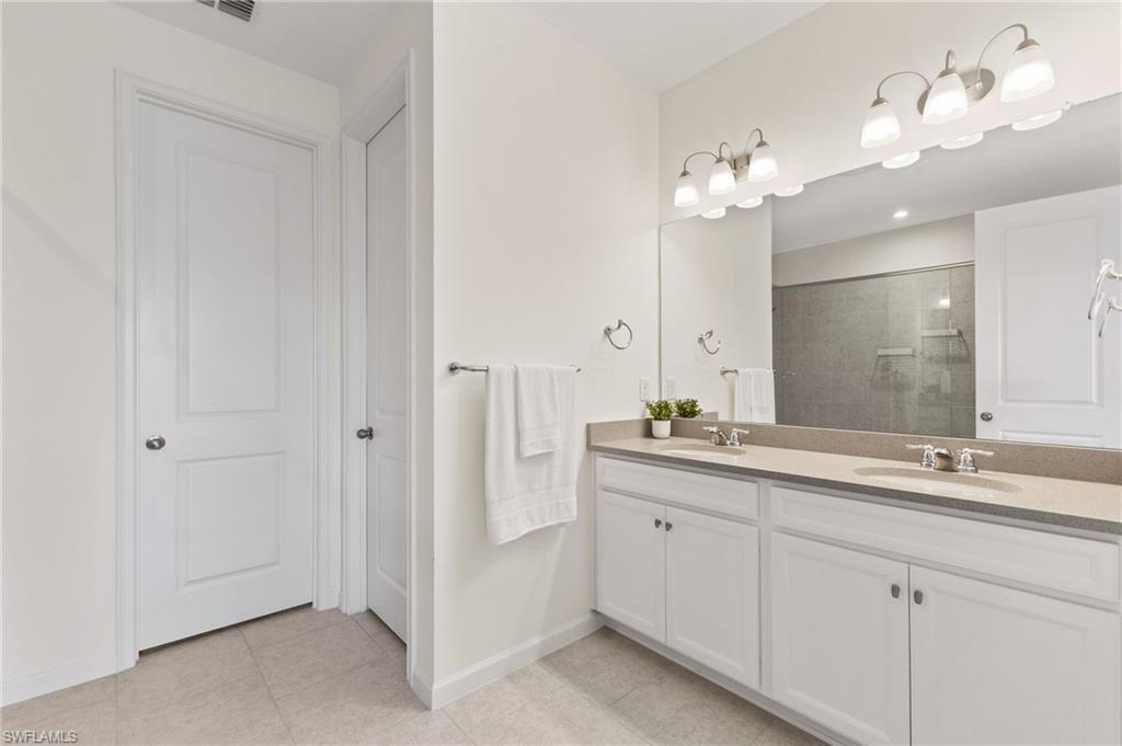 4607 Arboretum Circle, Unit 202 Naples, FL 34112 - Photo 10 of 39 a bathroom with a double vanity sink and a mirror