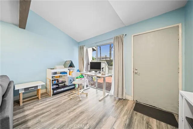 a living room with furniture a wooden floor and a potted plant