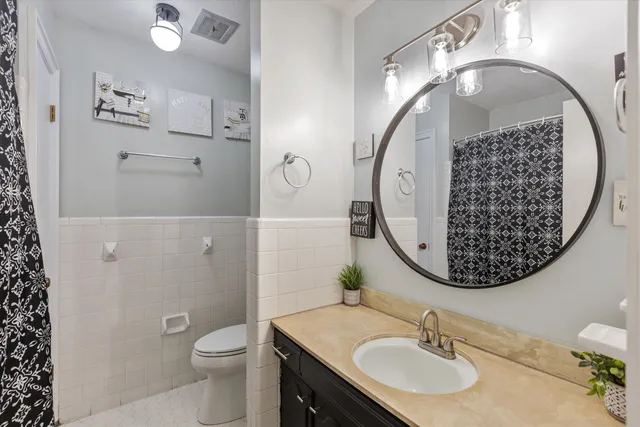 a bathroom with a sink mirror and toilet