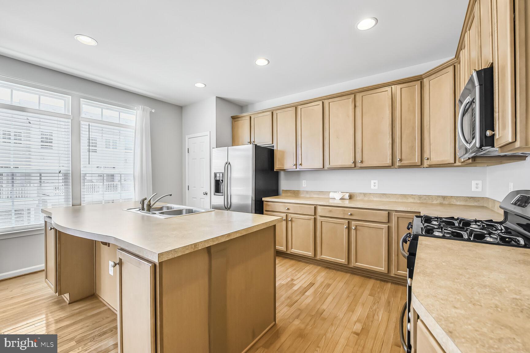 42952 Miltec Terrace Chantilly, VA 20152 - Photo 11 of 30 a kitchen with a sink stove and cabinets