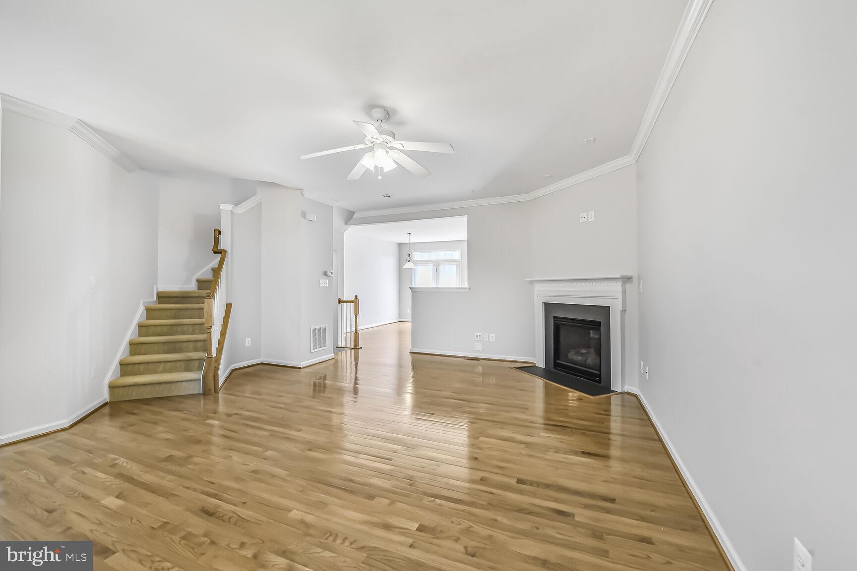 42952 Miltec Terrace Chantilly, VA 20152 - Photo 6 of 30 a view of an empty room with wooden floor fireplace and a window