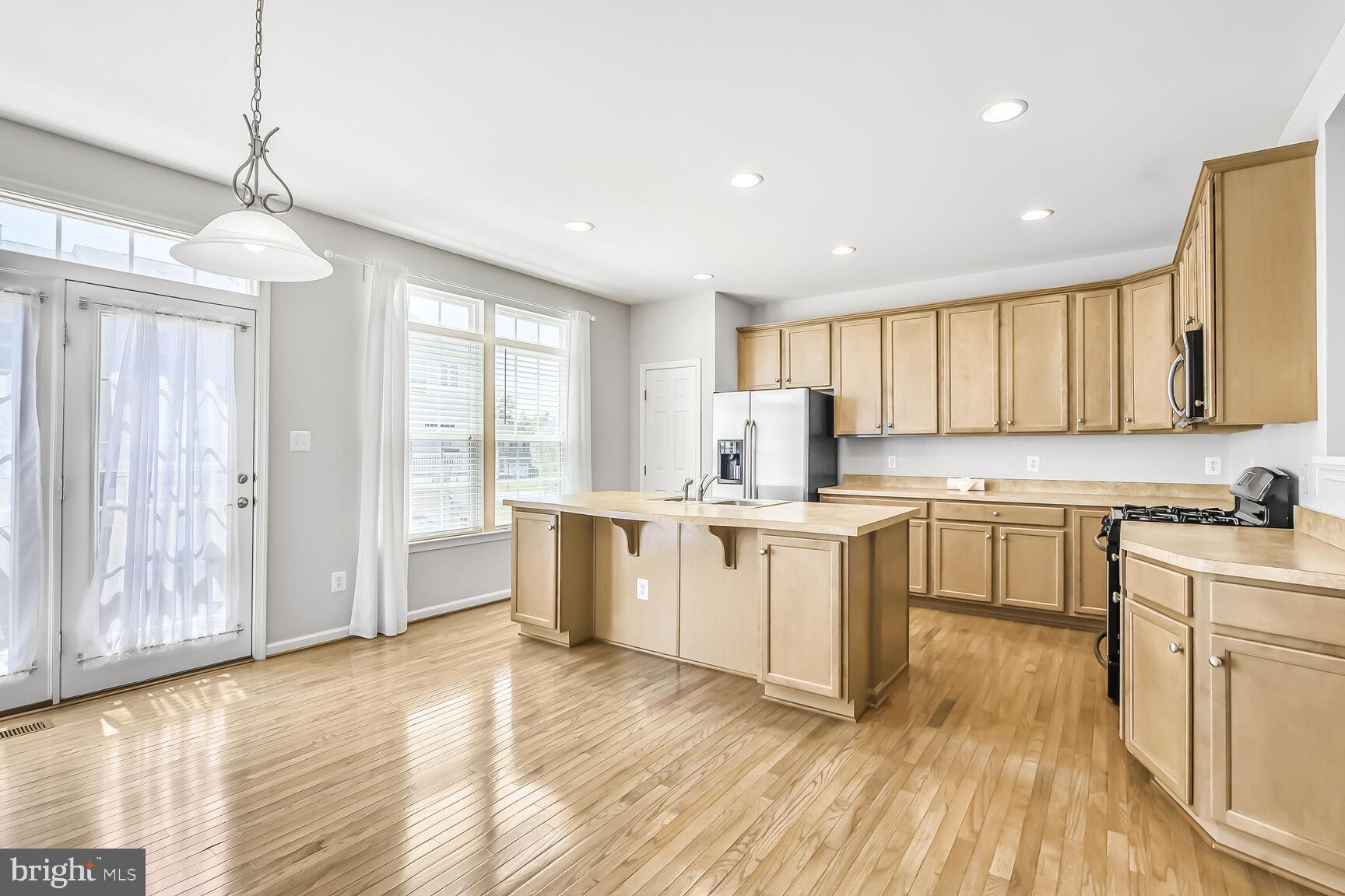 42952 Miltec Terrace Chantilly, VA 20152 - Photo 9 of 30 a kitchen with granite countertop a stove top oven a sink a counter space and cabinets