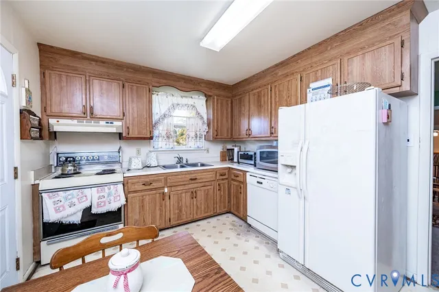 a kitchen with stainless steel appliances granite countertop a refrigerator sink and wooden cabinets