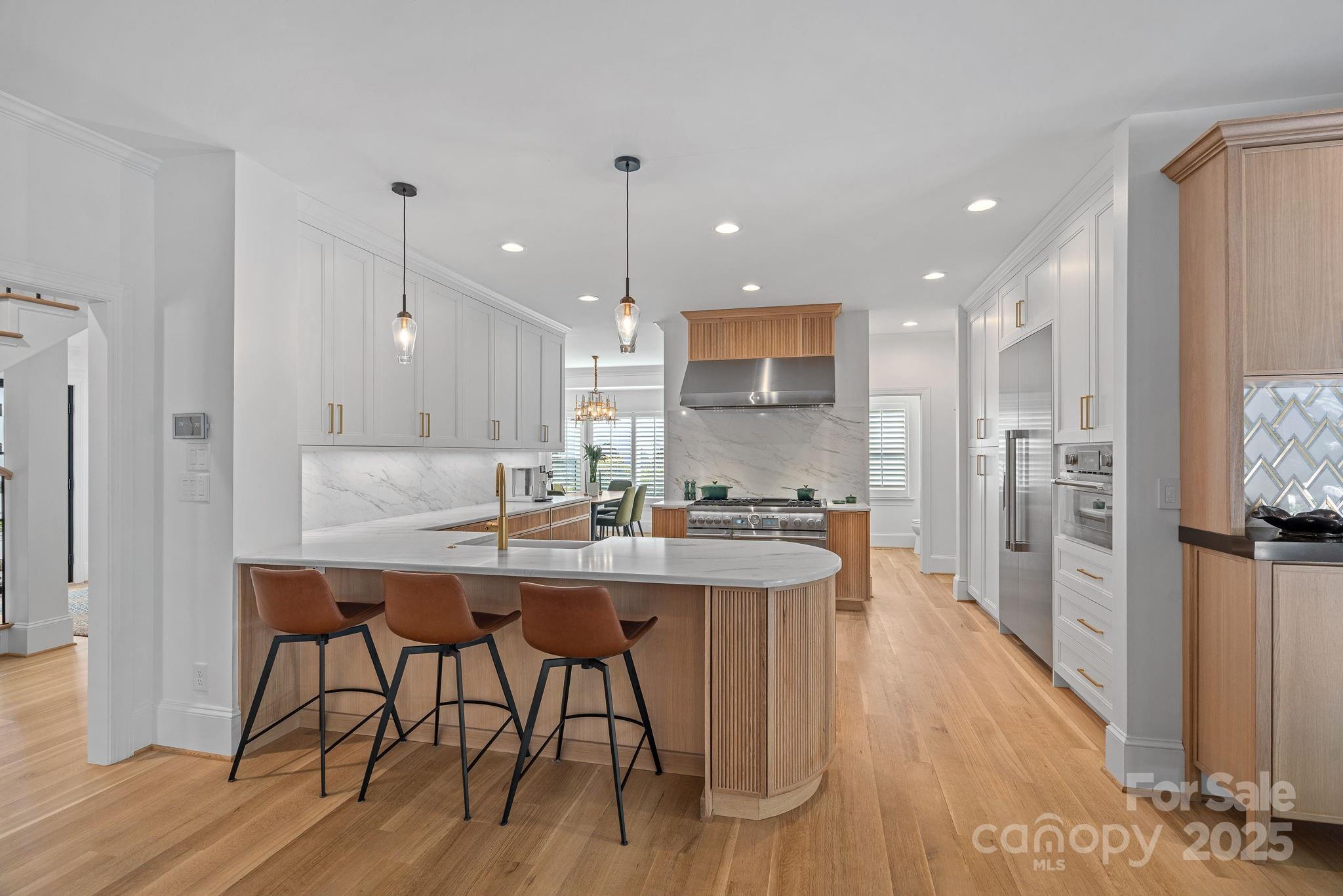 18613 John Connor Road Cornelius, NC 28031 - Photo 13 of 48 a kitchen with stainless steel appliances kitchen island granite countertop a table chairs sink and cabinets