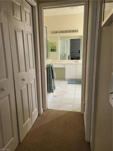 a view of a hallway with a glass door and a bathroom