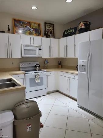 a kitchen with stainless steel appliances granite countertop a sink a stove a refrigerator and cabinets