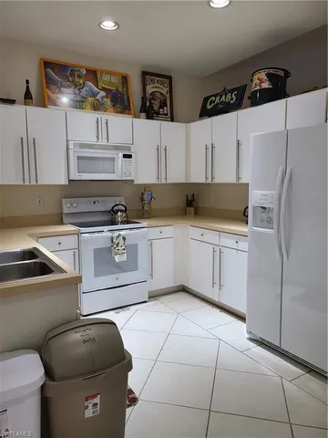 a kitchen with stainless steel appliances granite countertop a sink a stove a refrigerator and cabinets