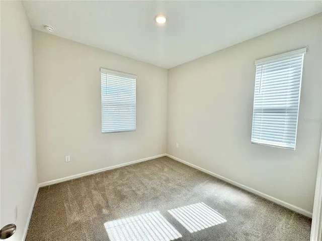 an empty room with closet and windows