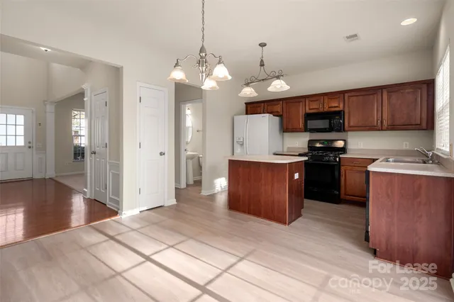 a kitchen with a stove a sink and a window