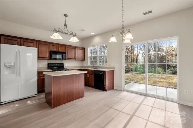 a kitchen with stainless steel appliances granite countertop a stove a refrigerator and a sink