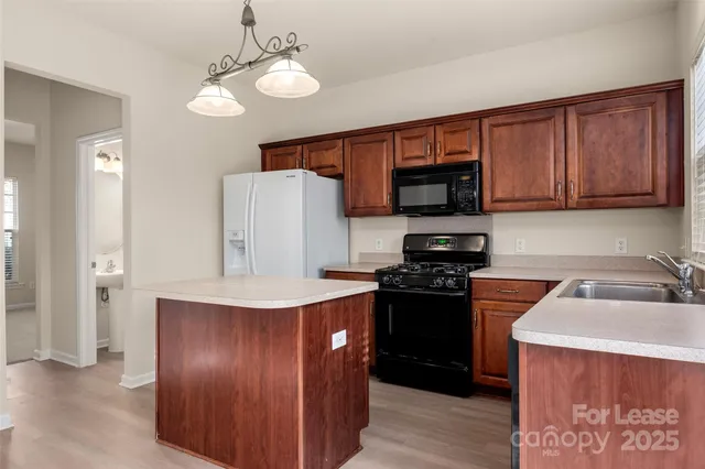 a view of an empty room with a kitchen stove and a window