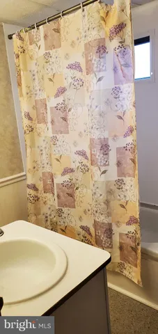 a bathroom with a sink and a shower curtain