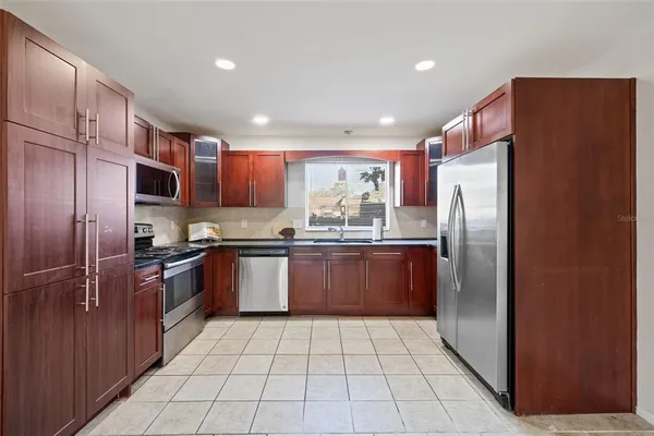 a kitchen with stainless steel appliances granite countertop a refrigerator and a sink